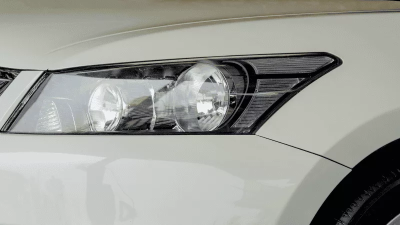 A modern car driving with LED headlights on